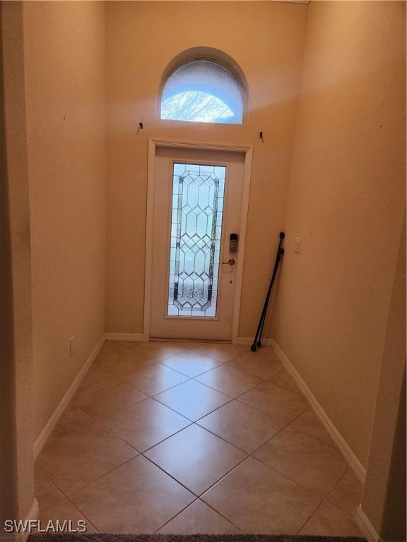 entryway with light tile patterned floors and baseboards