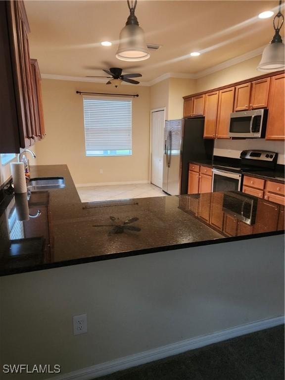 kitchen featuring a ceiling fan, appliances with stainless steel finishes, crown molding, pendant lighting, and a sink