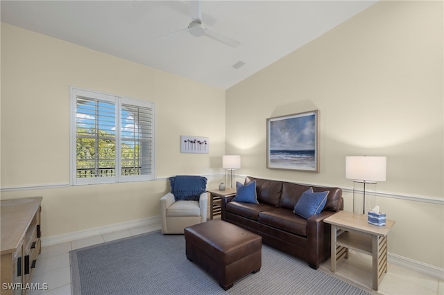 living area featuring baseboards, vaulted ceiling, a ceiling fan, and light tile patterned flooring