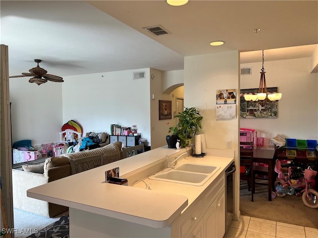 kitchen featuring black dishwasher, light countertops, a sink, and visible vents