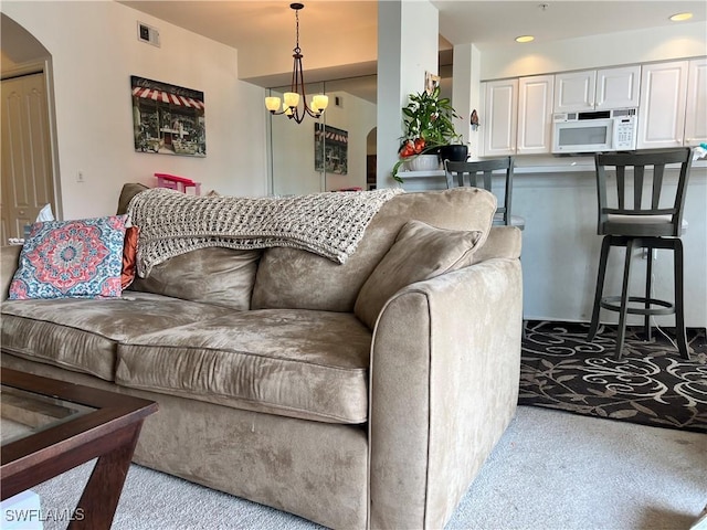 living room with arched walkways, a notable chandelier, recessed lighting, light colored carpet, and visible vents