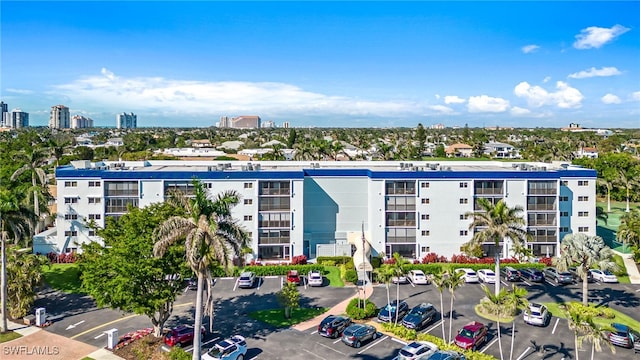 view of property with uncovered parking and a city view