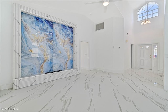 foyer with marble finish floor, visible vents, high vaulted ceiling, baseboards, and ceiling fan with notable chandelier