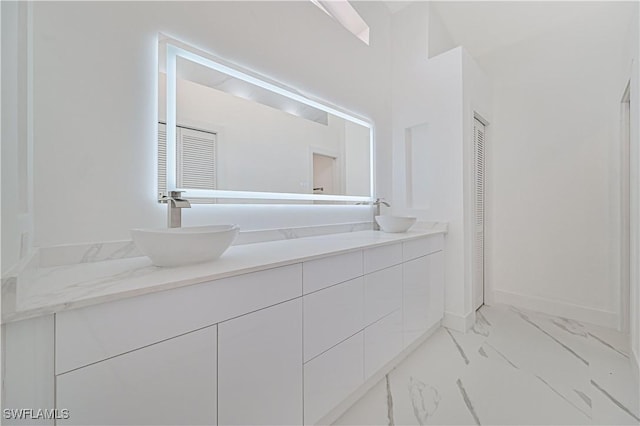 full bathroom with a closet, a sink, marble finish floor, and double vanity