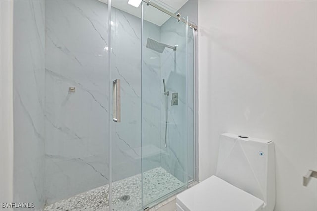 full bath featuring toilet and a marble finish shower