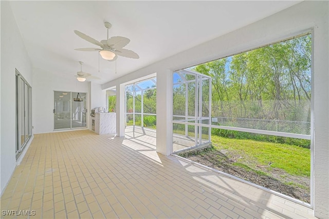 unfurnished sunroom featuring ceiling fan