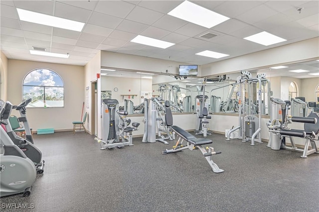 gym featuring baseboards, visible vents, and a drop ceiling