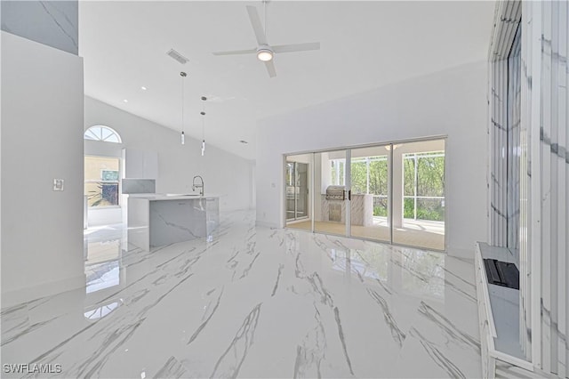 unfurnished living room with high vaulted ceiling, a sink, visible vents, a ceiling fan, and marble finish floor