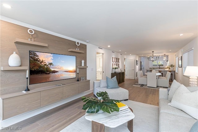 living room featuring recessed lighting, an inviting chandelier, and wood finished floors