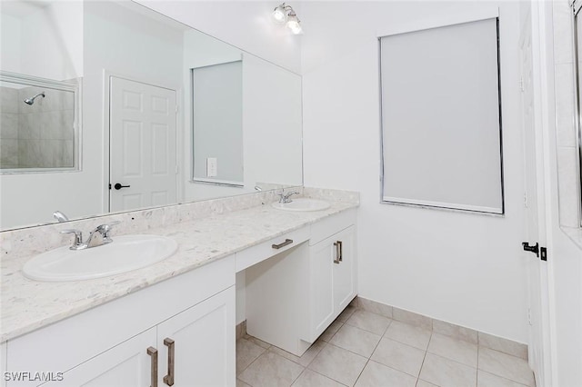 bathroom featuring double vanity, tiled shower, a sink, and tile patterned floors