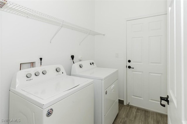 laundry room with laundry area, dark wood finished floors, and separate washer and dryer