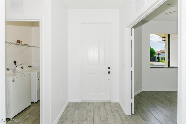 laundry room with laundry area, visible vents, light wood finished floors, and washing machine and clothes dryer