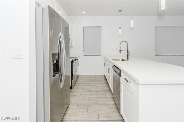 kitchen featuring light countertops, appliances with stainless steel finishes, white cabinetry, and pendant lighting