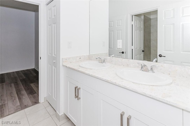 bathroom with double vanity, a sink, and tile patterned floors