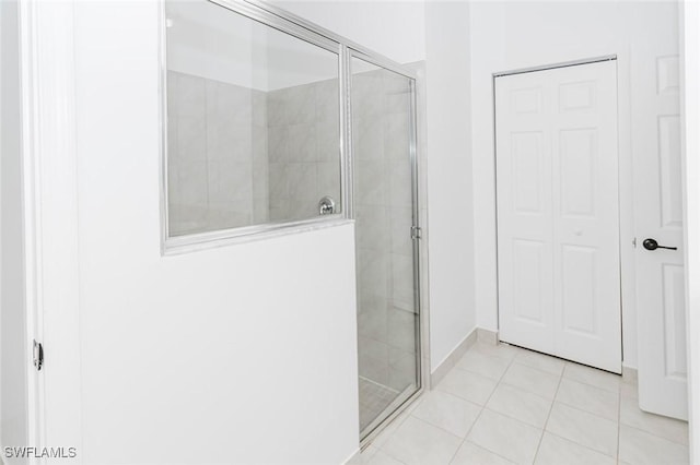 bathroom featuring a closet, a shower stall, and tile patterned floors