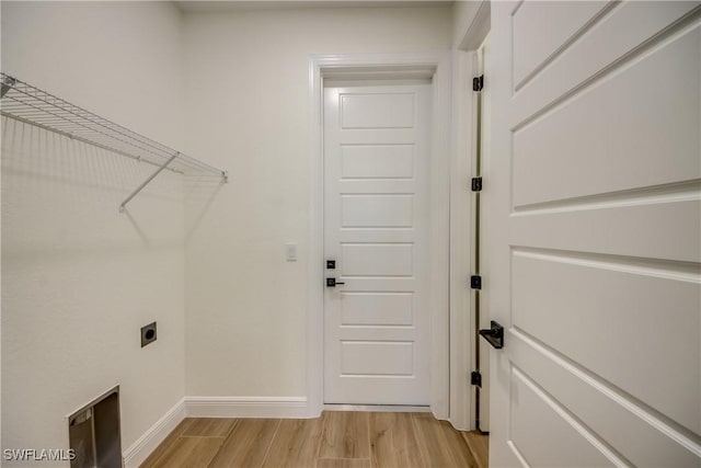 laundry area with baseboards, laundry area, light wood-type flooring, and hookup for an electric dryer