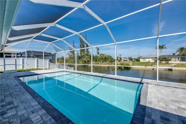 outdoor pool featuring a lanai, a water view, a patio, and fence