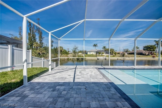 view of patio / terrace with a lanai, a water view, fence, and an outdoor pool