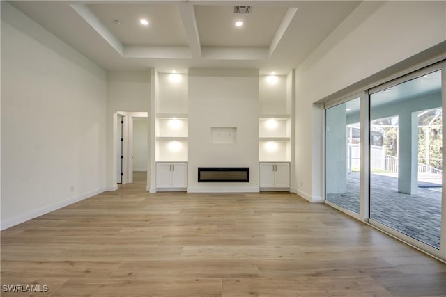 unfurnished living room with light wood-style floors, a glass covered fireplace, visible vents, and baseboards