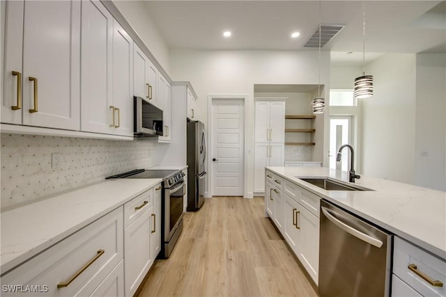 kitchen with a sink, visible vents, appliances with stainless steel finishes, open shelves, and pendant lighting