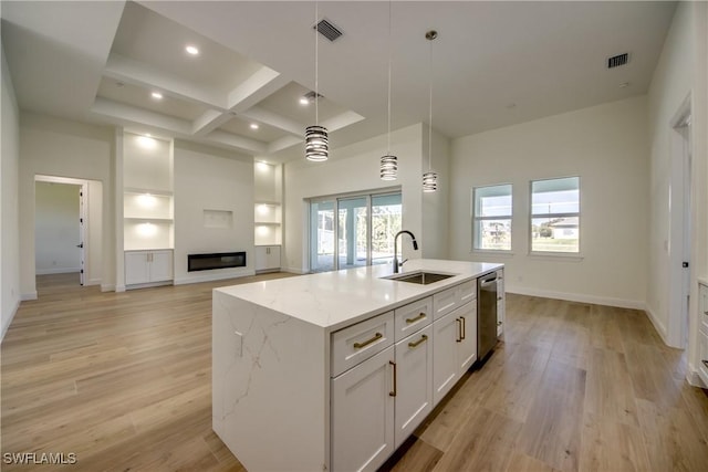 kitchen with pendant lighting, white cabinetry, a sink, an island with sink, and coffered ceiling