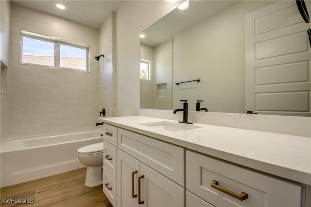 bathroom featuring vanity, bathtub / shower combination, wood finished floors, and toilet