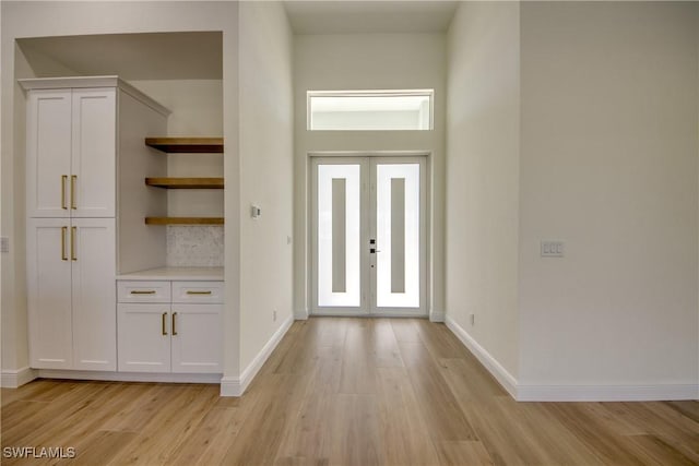 foyer entrance featuring baseboards and light wood-style floors