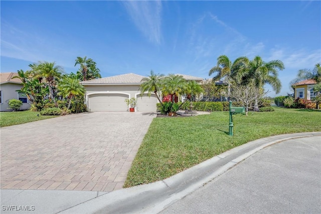 view of front facade featuring a garage, a front yard, decorative driveway, and a tile roof