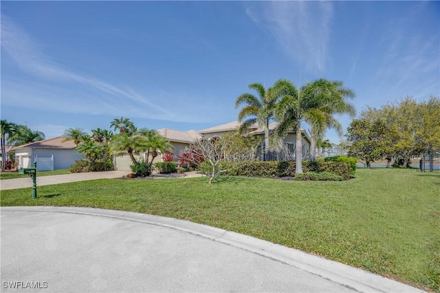 view of front of home featuring driveway, a front lawn, and an attached garage