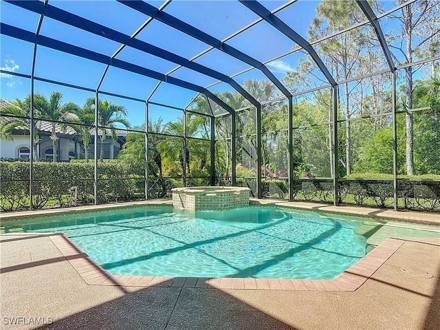 view of pool with glass enclosure, a pool with connected hot tub, and a patio area