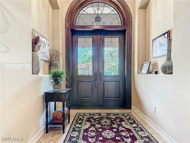 entrance foyer with baseboards and french doors