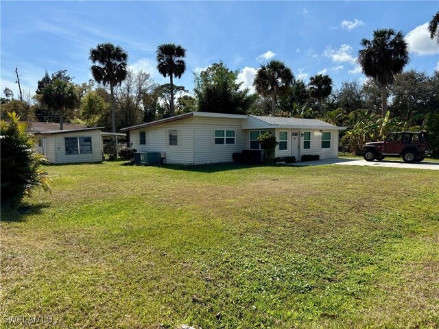 ranch-style home with a front lawn, an outdoor structure, and central air condition unit