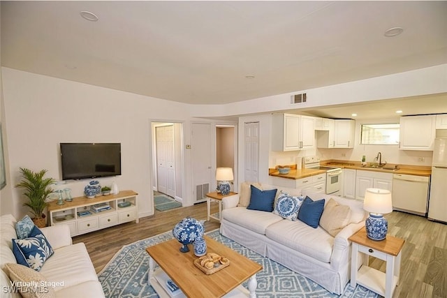 living room featuring wood finished floors, visible vents, and recessed lighting