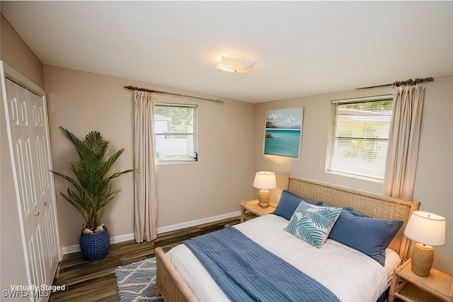 bedroom featuring a closet, dark wood finished floors, and baseboards