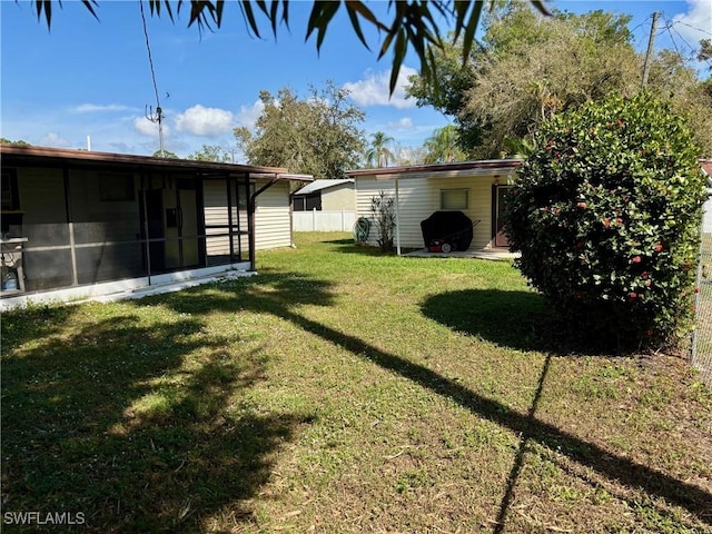 view of yard with a sunroom and fence