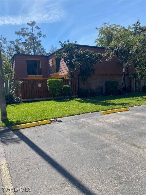 view of front of house with uncovered parking and a front yard