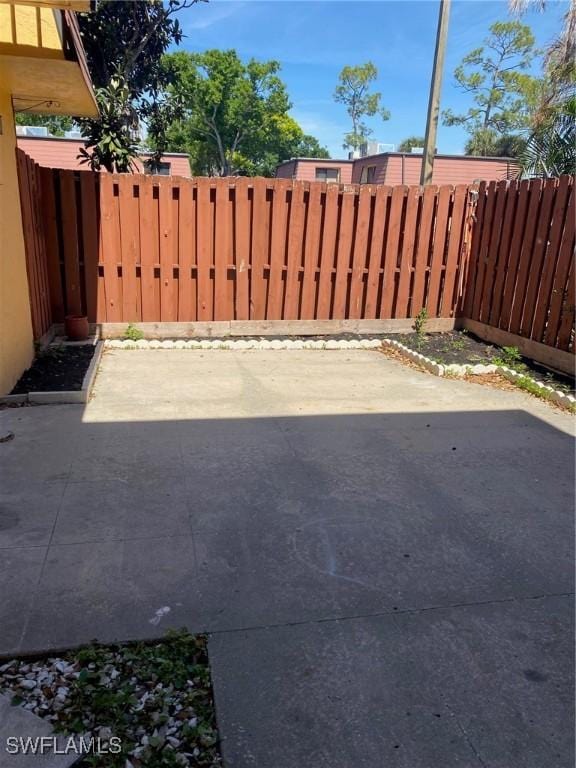 view of gate featuring a fenced backyard and a patio