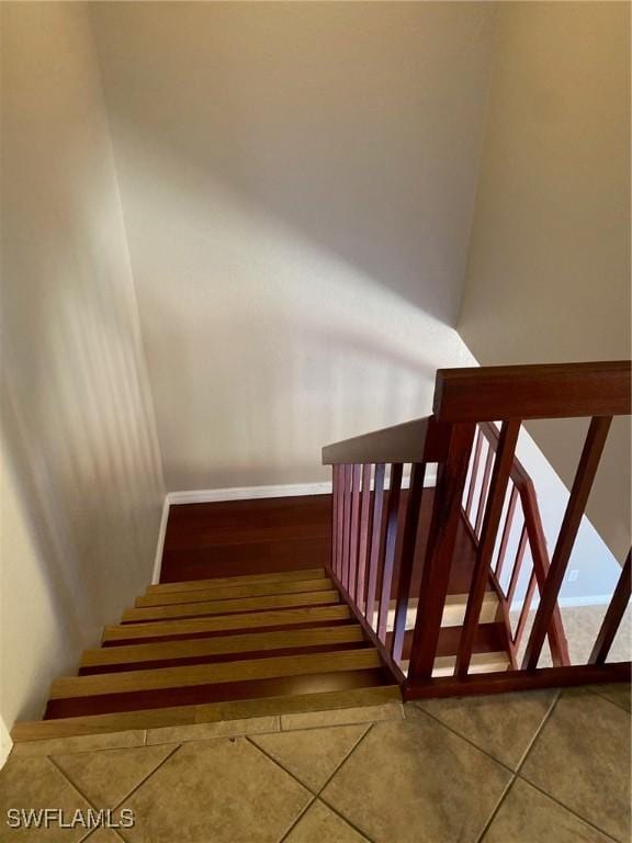 stairs featuring baseboards and tile patterned floors