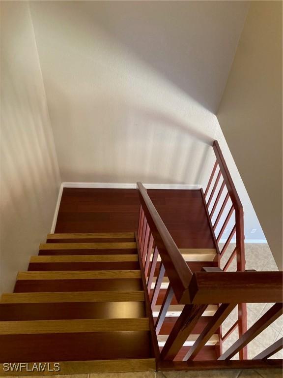 stairway with baseboards and wood finished floors