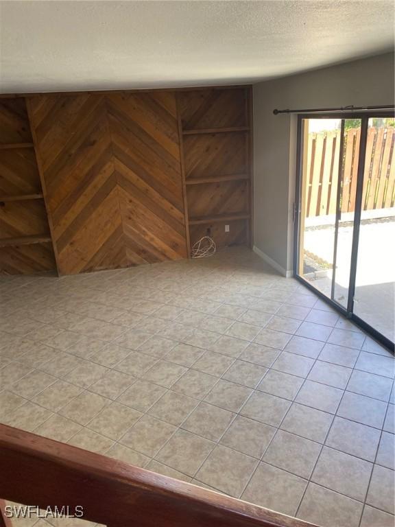 interior space with light tile patterned floors and a textured ceiling