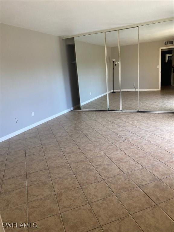 unfurnished bedroom featuring visible vents, baseboards, and a closet