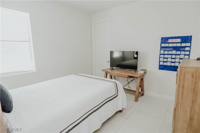 bedroom featuring baseboards and light tile patterned floors