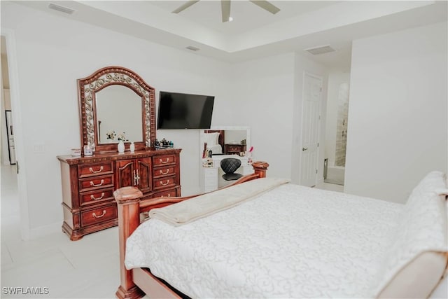 bedroom featuring a ceiling fan, a raised ceiling, visible vents, and baseboards