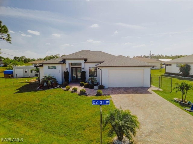 prairie-style home featuring a garage, a front yard, decorative driveway, and fence