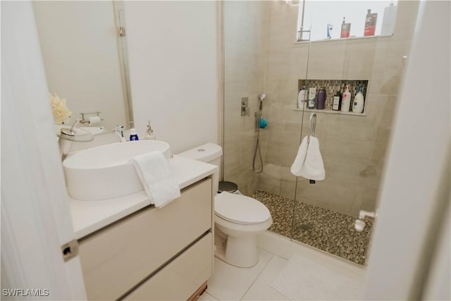 bathroom with a shower stall, vanity, toilet, and tile patterned floors