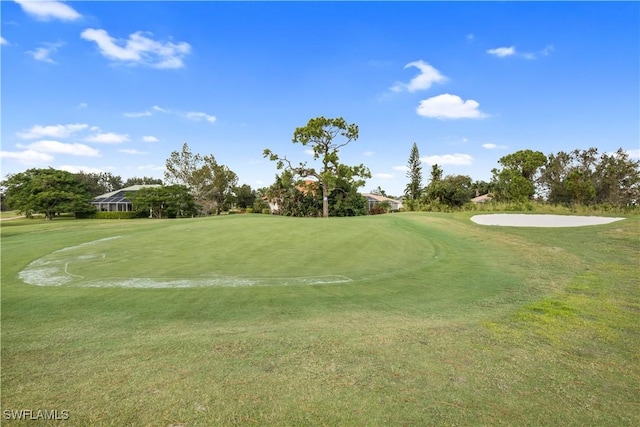 surrounding community featuring golf course view and a yard