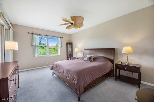 bedroom featuring light carpet, baseboards, and a ceiling fan