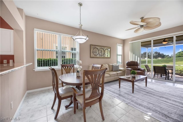 dining area with ceiling fan, baseboards, and light tile patterned floors