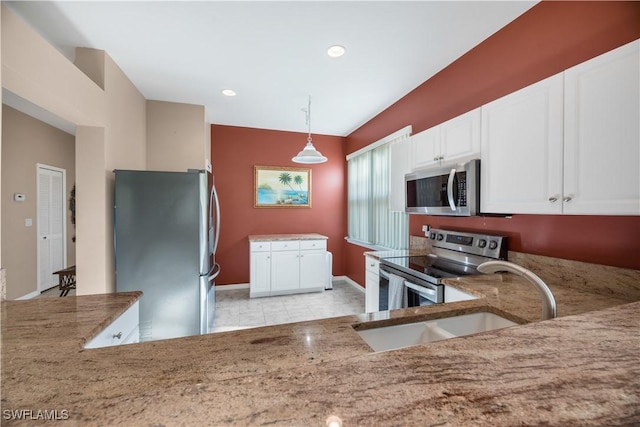 kitchen featuring baseboards, white cabinets, decorative light fixtures, stainless steel appliances, and a sink