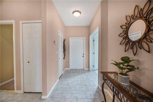 interior space featuring light tile patterned flooring and baseboards